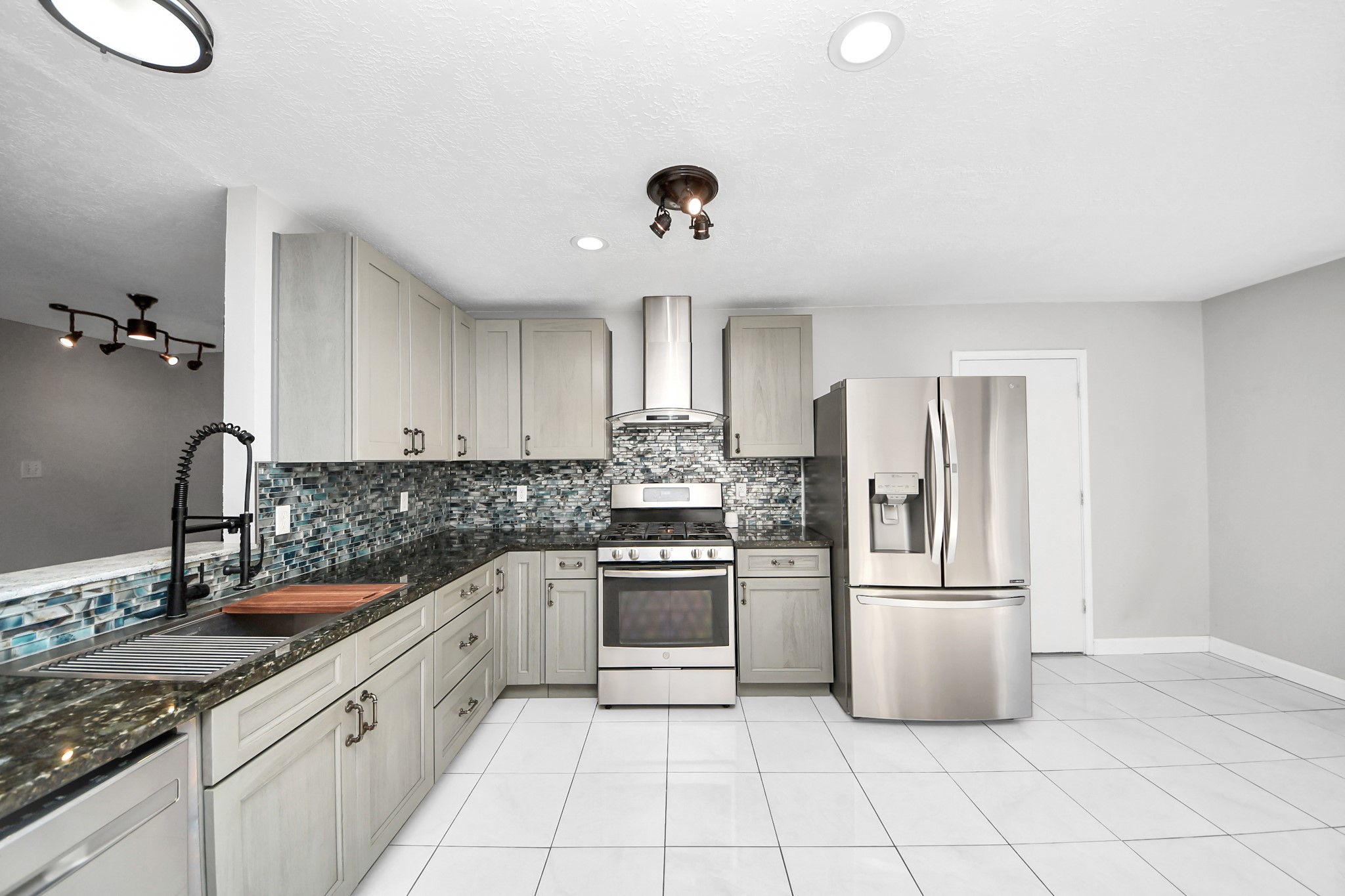 28707 Stapleford Street Spring, TX 77386 - Photo 11 of 38 a kitchen with granite countertop a refrigerator and a sink