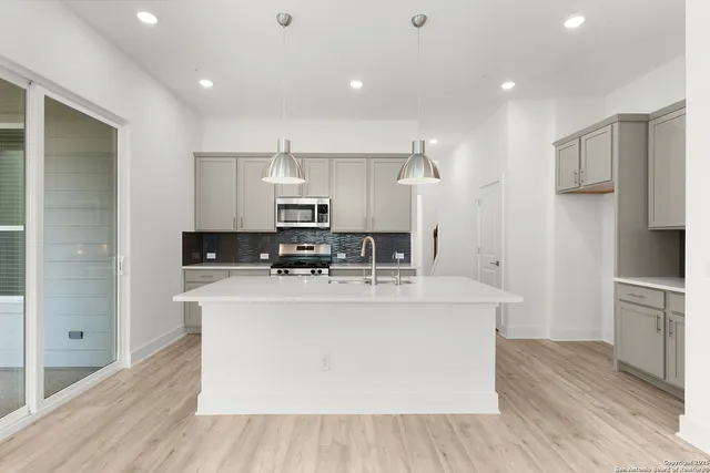 a view of kitchen with stainless steel appliances refrigerator stove microwave and cabinets