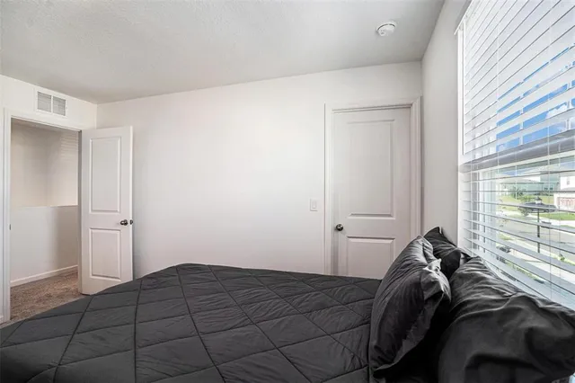 a bed sitting in a bedroom next to a window