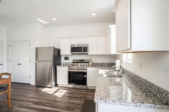 a kitchen with stainless steel appliances granite countertop a refrigerator stove and microwave