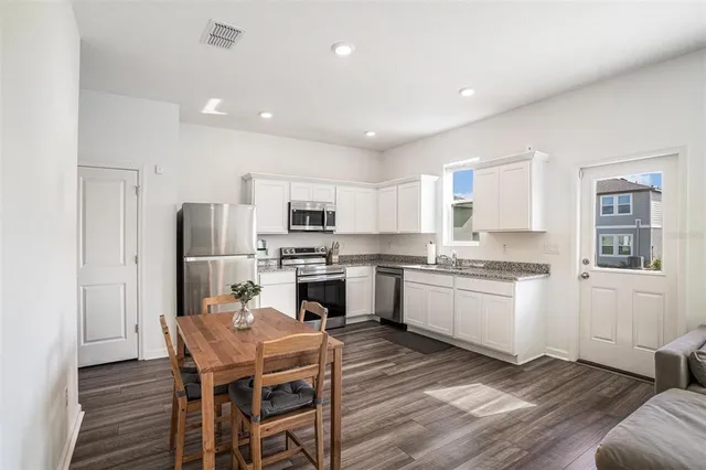 a kitchen with stainless steel appliances kitchen island granite countertop a kitchen island hardwood floor and a sink