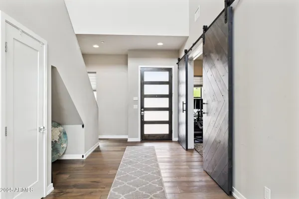 a view of a hallway with wooden floor and staircase