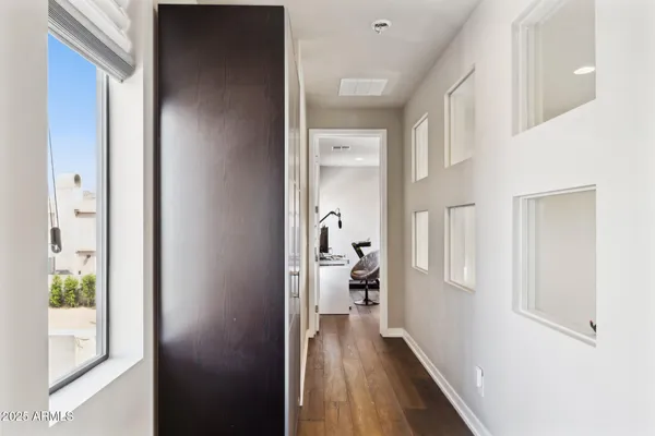 a view of a hallway with wooden floor and a living room