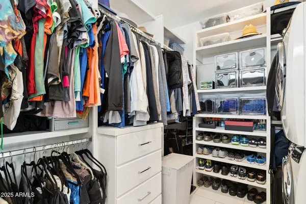 a view of walk in closet with clothes and shoes