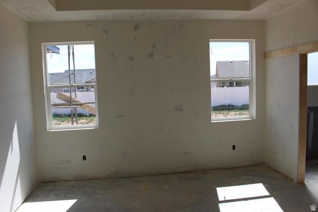 4933 East Remington Road Cedar City, UT 84721 - Photo 15 of 33 Room featuring two double-hung windows, a tray ceiling, and unfinished walls ready for customization