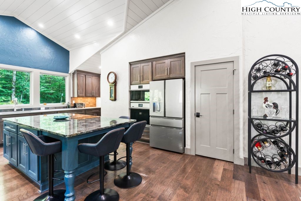1325 Golf Course Road Linville, NC 28646 - Photo 18 of 46 a view of a dining room with furniture one side kitchen view and wooden floor