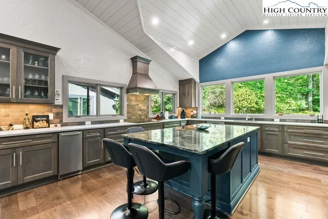 a kitchen with kitchen island granite countertop a sink window and chairs