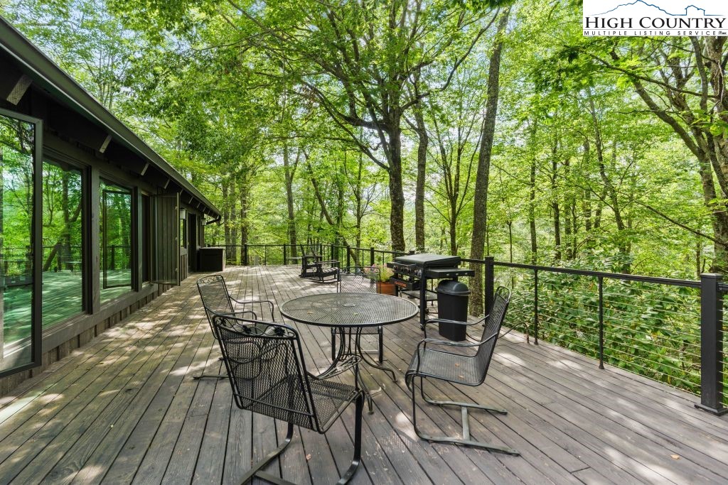 1325 Golf Course Road Linville, NC 28646 - Photo 21 of 46 a view of a patio with table and chairs with wooden floor and fence