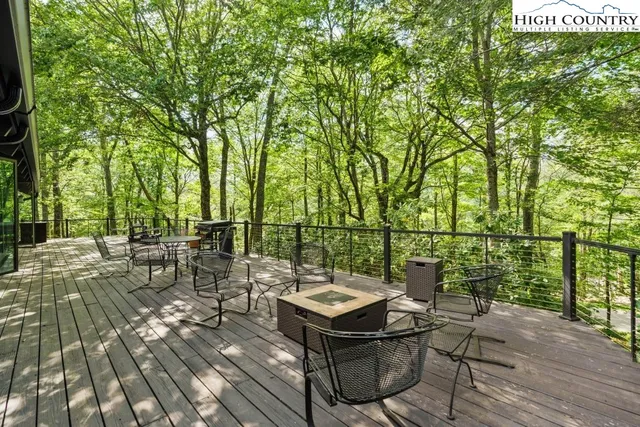 a view of a patio with table and chairs and potted plants with wooden floor and fence