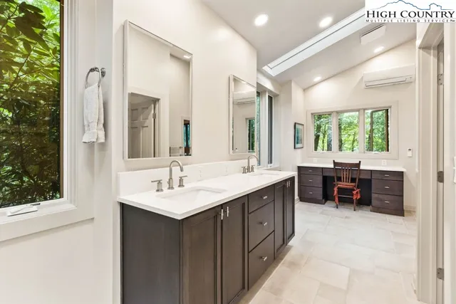 a en suite bathroom with a double vanity sink and a mirror