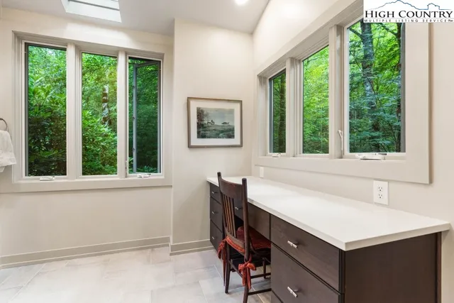 a view of a room that has a window and furniture