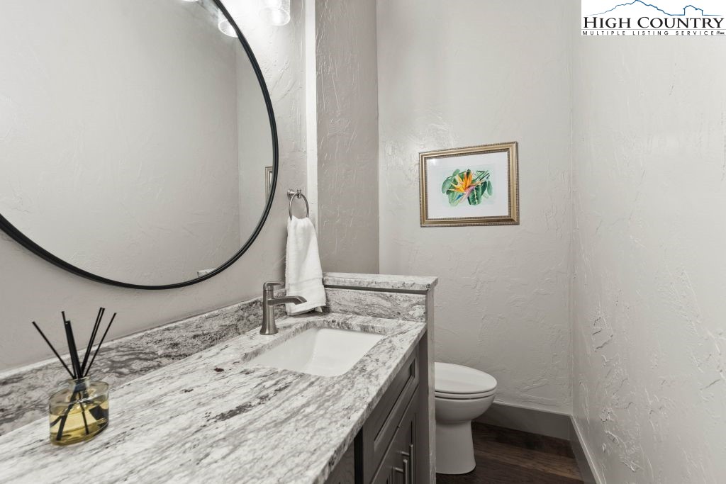 1325 Golf Course Road Linville, NC 28646 - Photo 33 of 46 a bathroom with a granite countertop sink a toilet and a mirror