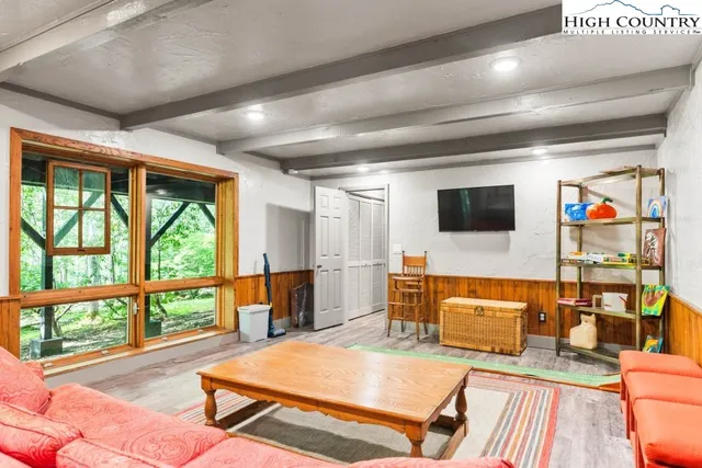 a living room with furniture flat screen tv and a large window