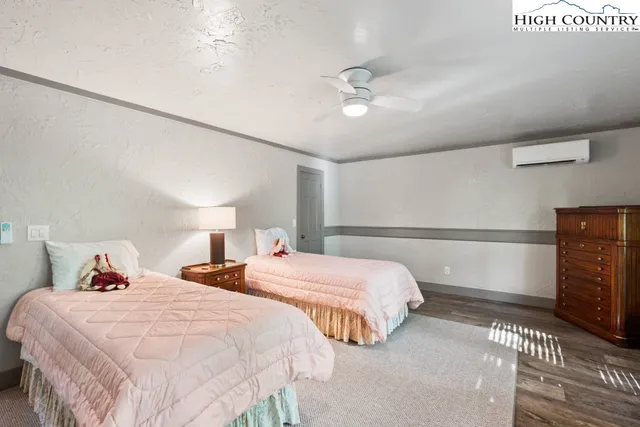 a bedroom with two beds and a ceiling fan