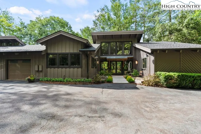 a front view of a house with a yard and trees