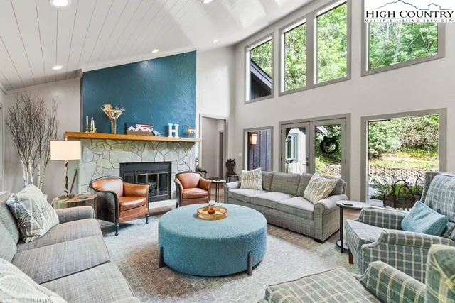 a living room with furniture a large window and a fireplace