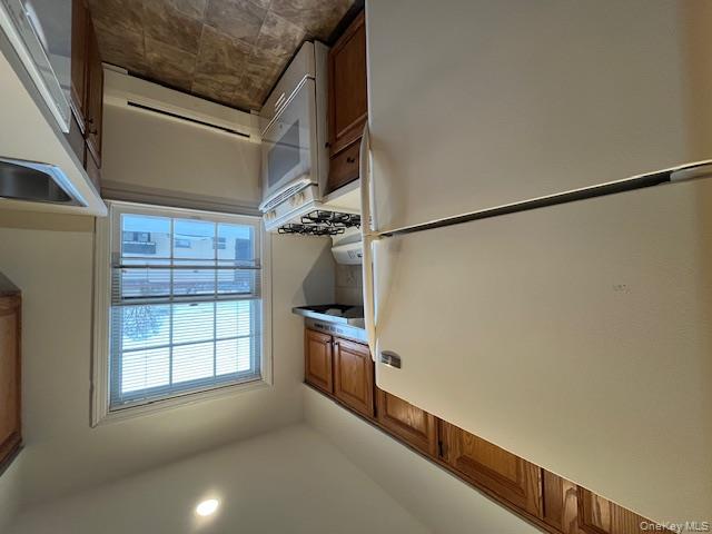 84 Shore Road, Unit D2 Port Washington, NY 11050 - Photo 6 of 12 a kitchen with stainless steel appliances granite countertop a refrigerator and a sink