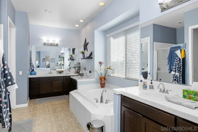 a bathroom with a granite countertop sink double vanity and a mirror