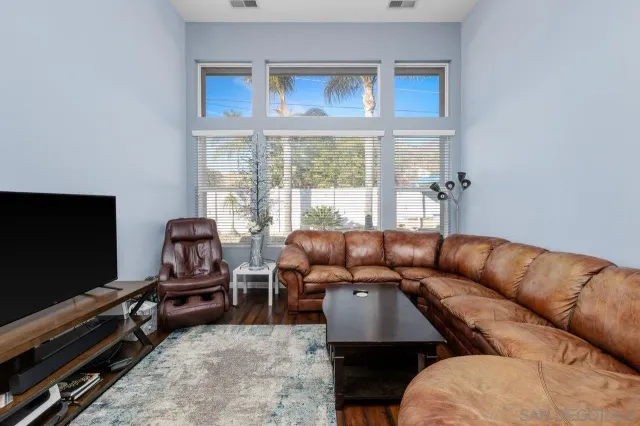 a living room with furniture workspace and a flat screen tv