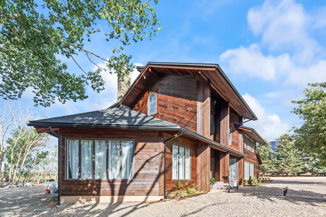 460 Omni Point Road Central Valley, UT 84754 - Photo 75 of 101 Wood-sided exterior featuring multiple windows, a prominent roofline, and a gravel driveway