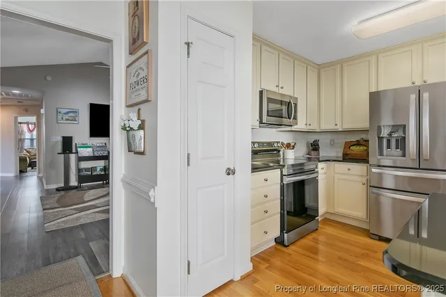 a kitchen with cabinets stainless steel appliances and wooden floor