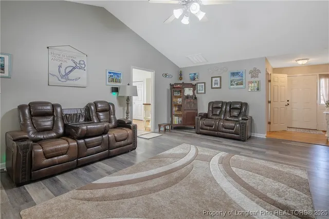 a living room with furniture and a wooden floor
