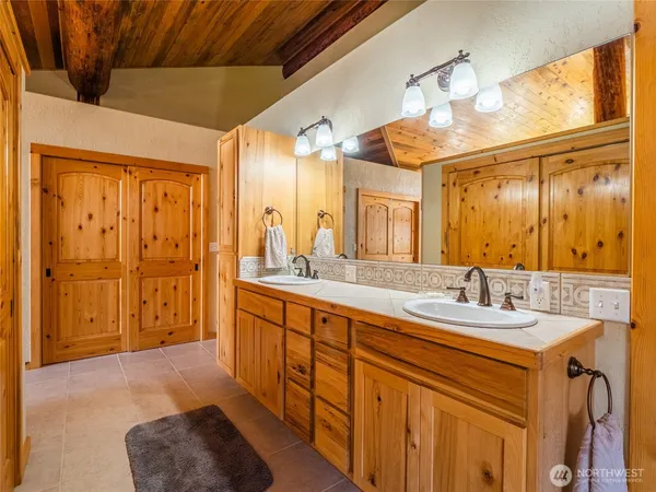 a spacious bathroom with a double vanity sink a mirror and a shower