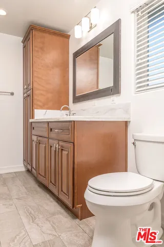 a bathroom with a toilet a sink and a mirror