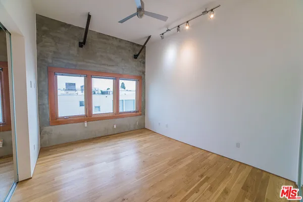 a view of hallway with window and wooden floor