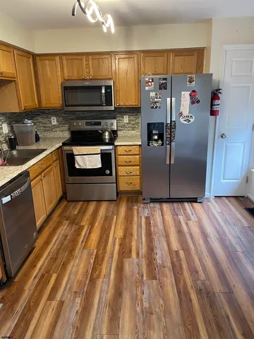 a kitchen with stainless steel appliances granite countertop a refrigerator and a stove top oven