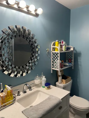 a bathroom with a sink and mirror with toilet