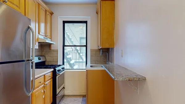 a kitchen with a refrigerator a stove and a window