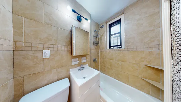 a bathroom with a tub sink and mirror