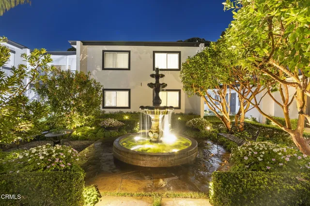 a view of a fountain in the backyard of a house