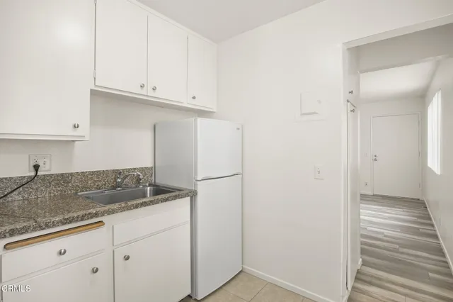 a kitchen with granite countertop white cabinets and a sink