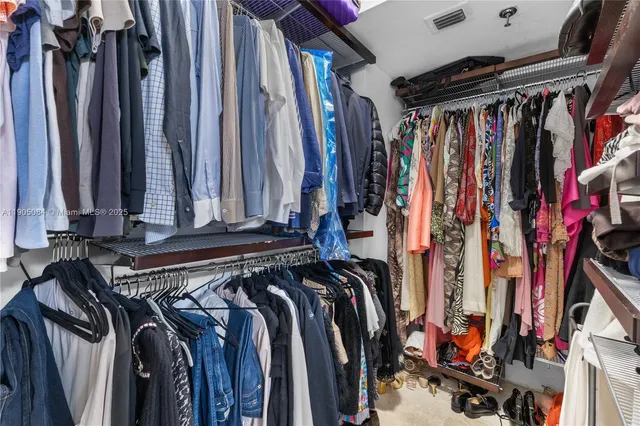a view of walk in closet with clothes and shoes
