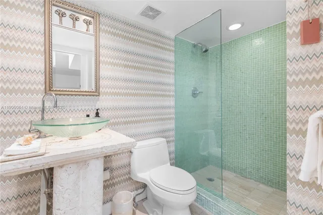 a bathroom with a sink toilet vanity and shower