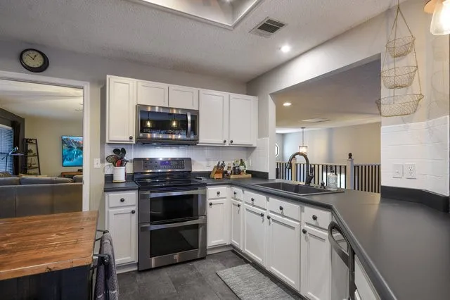a kitchen with sink a microwave and cabinets
