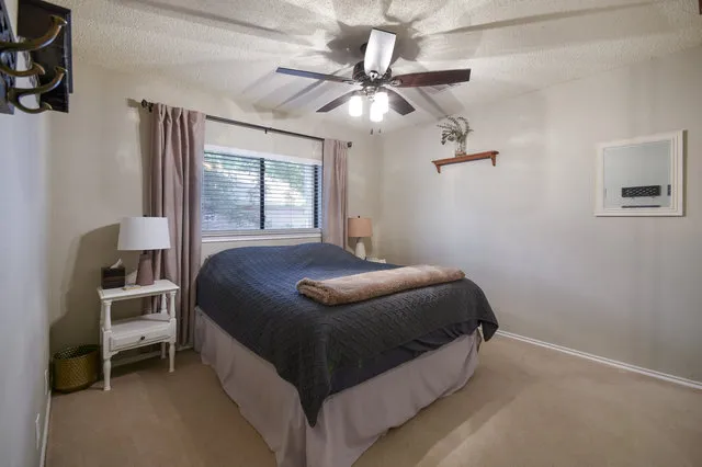 a bedroom with a bed and a chandelier fan