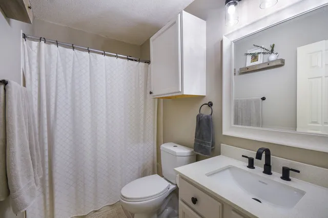 a bathroom with a toilet a sink and mirror