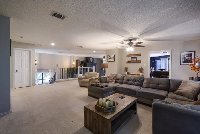 a living room with furniture a ceiling fan and a rug
