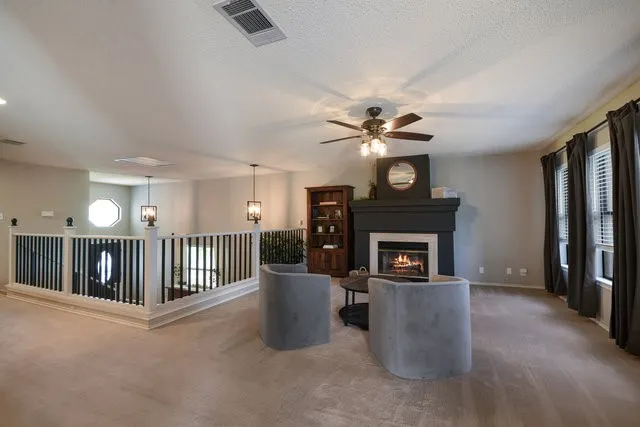 a living room with furniture a fireplace and a ceiling fan