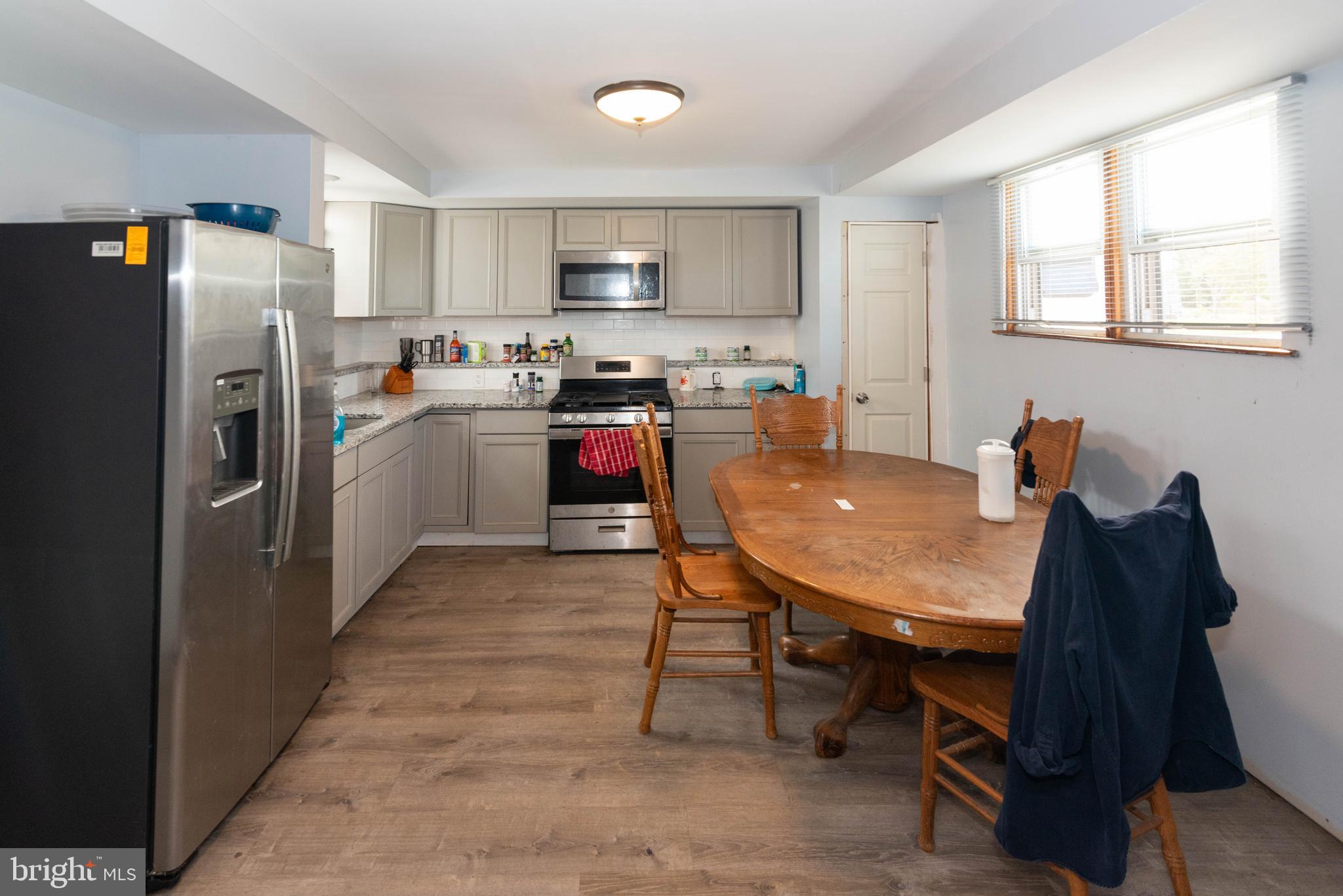 6510 North Point Road Edgemere, MD 21219 - Photo 33 of 56 a kitchen with a table chairs refrigerator and microwave