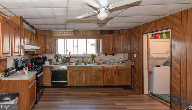 a kitchen with kitchen island granite countertop a sink cabinets and stainless steel appliances