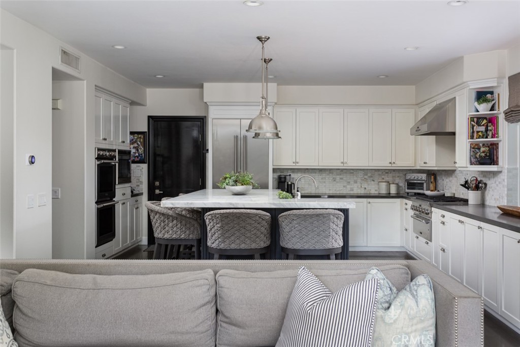 8 Madison Newport Beach, CA 92660 - Photo 11 of 34 a kitchen with granite countertop a refrigerator a stove a sink and white cabinets