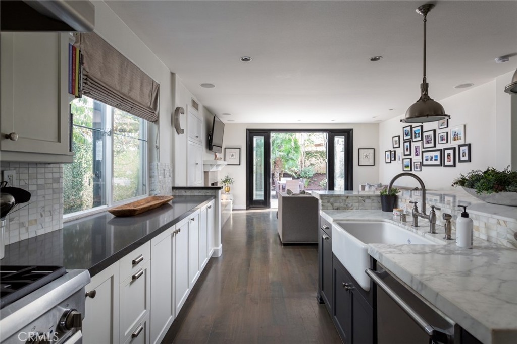 8 Madison Newport Beach, CA 92660 - Photo 9 of 34 a kitchen with granite countertop a sink a counter top space and living room area