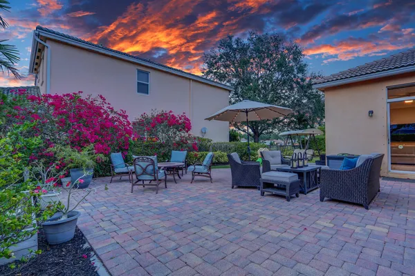 a view of a house with backyard and sitting area