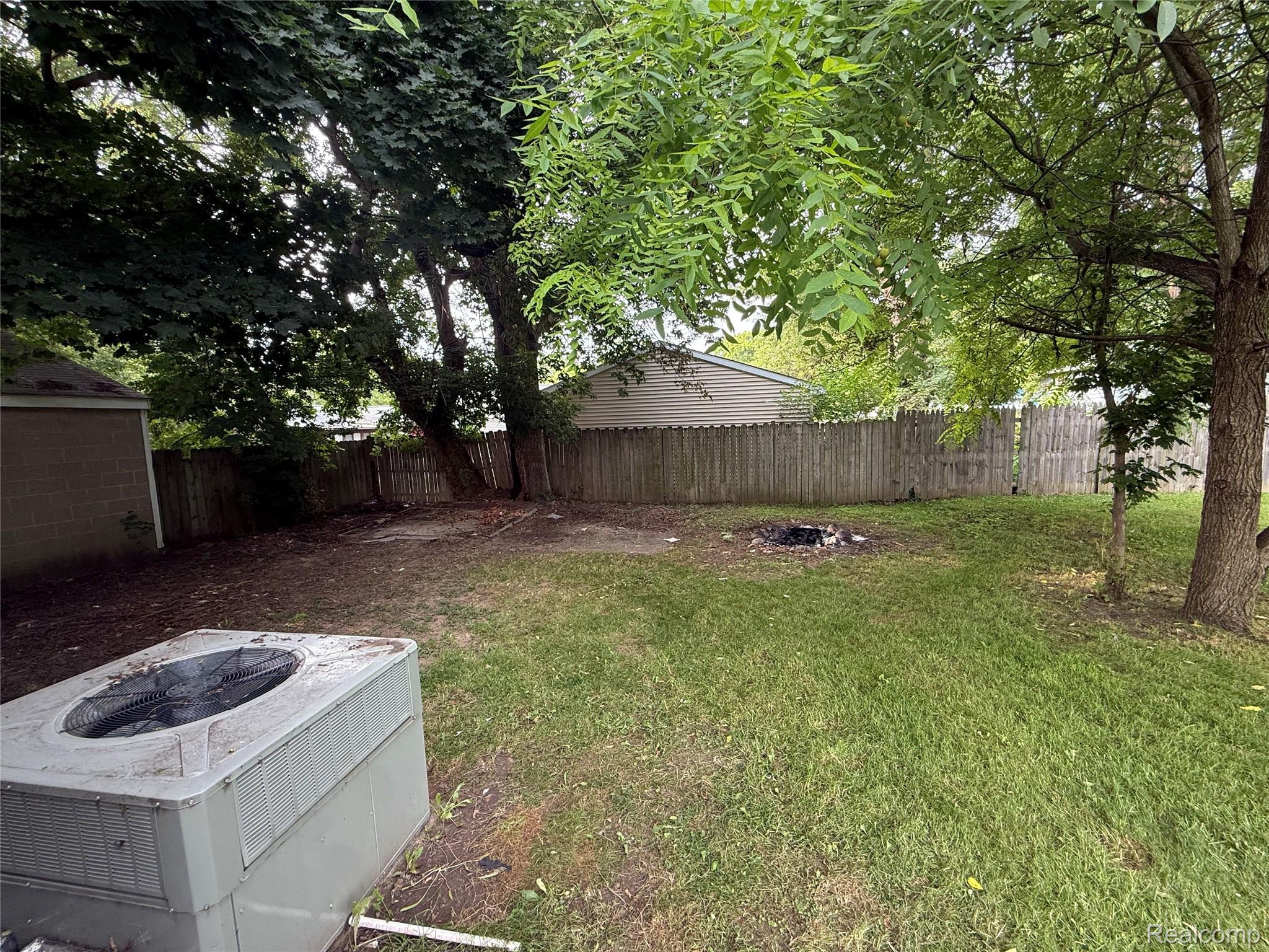 2194 East Bristol Road Burton, MI 48529 - Photo 13 of 13 Expansive backyard featuring a partial privacy fence, mature trees, and a grass lawn