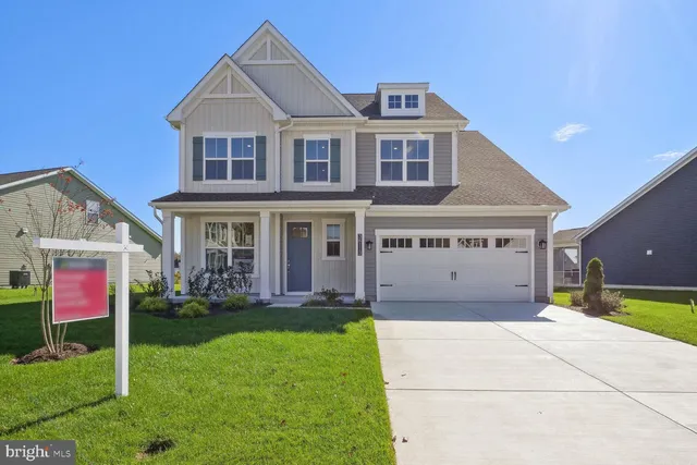 a view of a white house with a big yard and potted plants