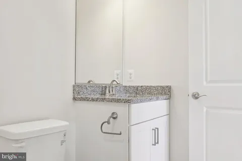 a bathroom with a granite countertop toilet and a sink